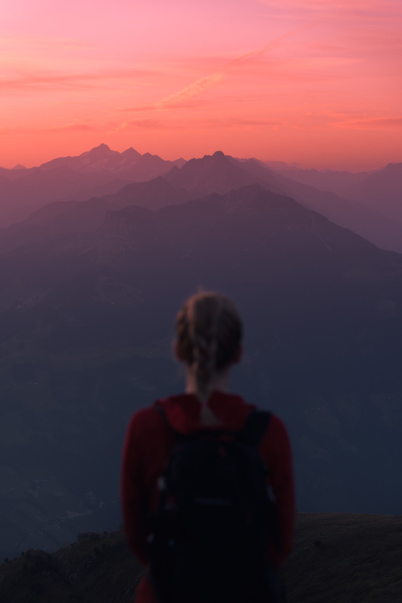 Woman staring out at pink sunrise