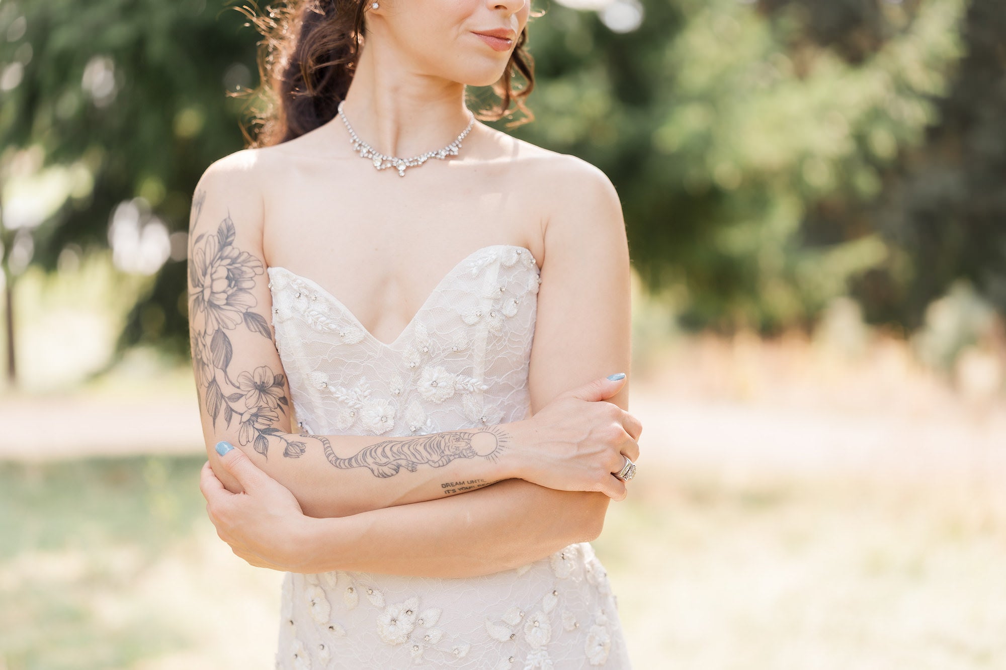 Portrait of bride with her arms crossing each other in front of her wedding dress