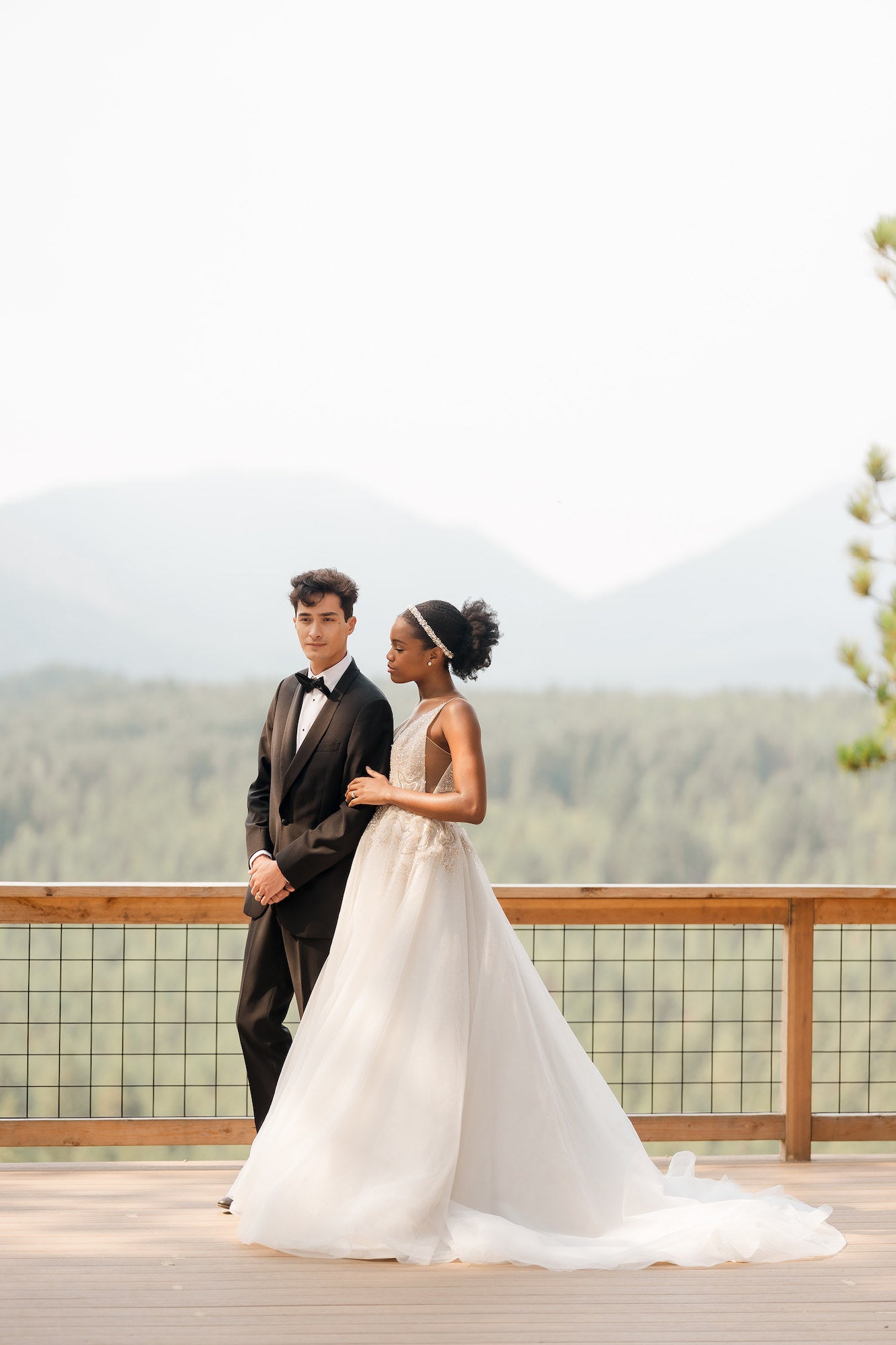 Bride and groom standing on path in front of sweet forest landscape