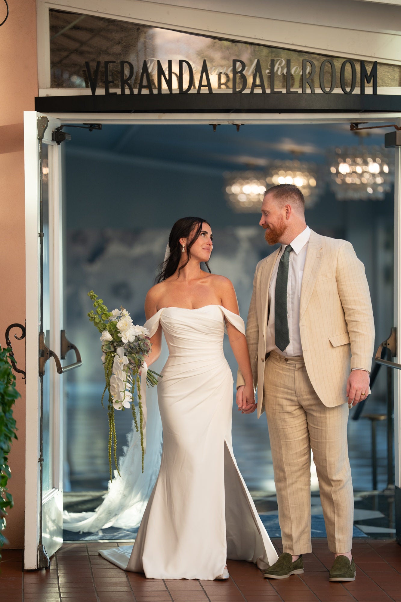 Bride and groom walking through doorway of Veranda Ballroom