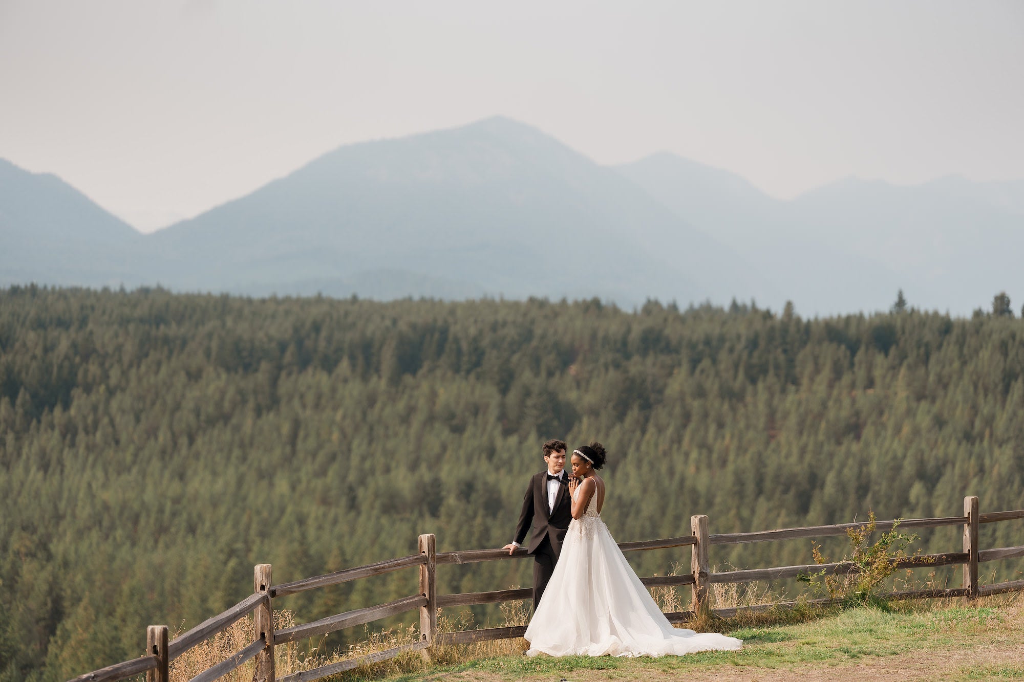 Bride and groom standing on path in front of sweet forest landscape
