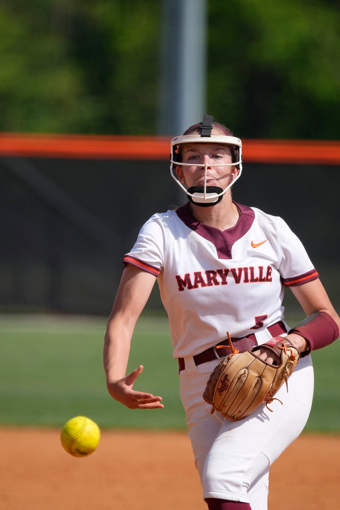 Maryville softball pitcher with a mask on releases her pitch.