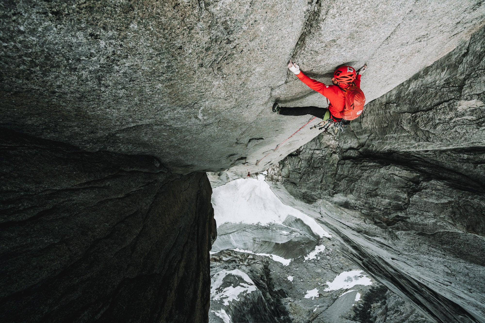 Photo looking down at a climber in red on a cliff.