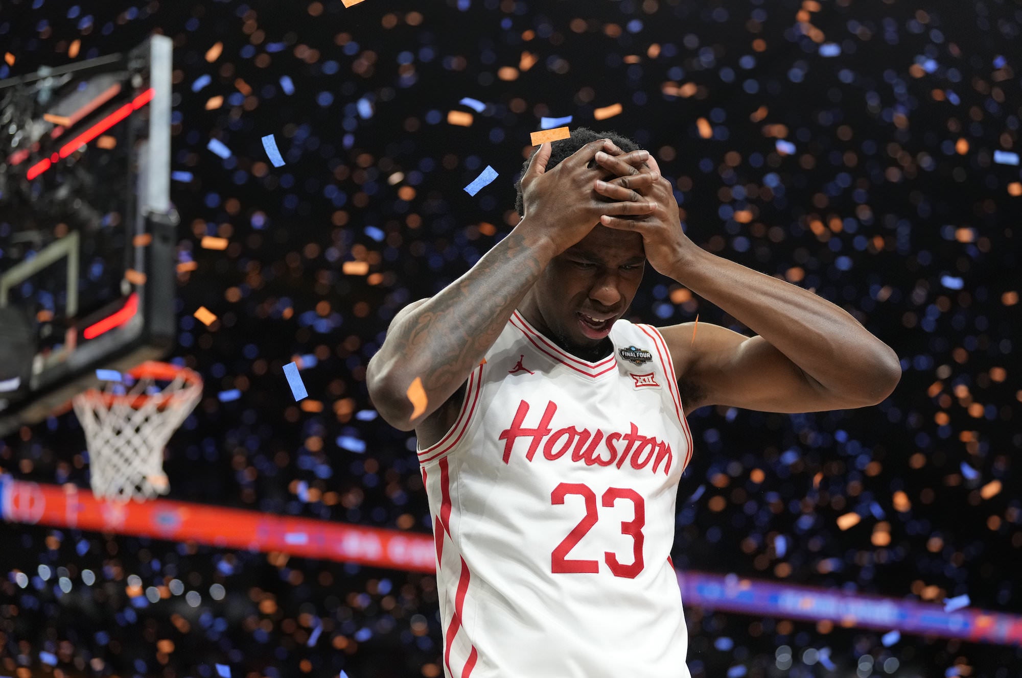Houston player holds his head amid falling confetti after the final buzzer.
