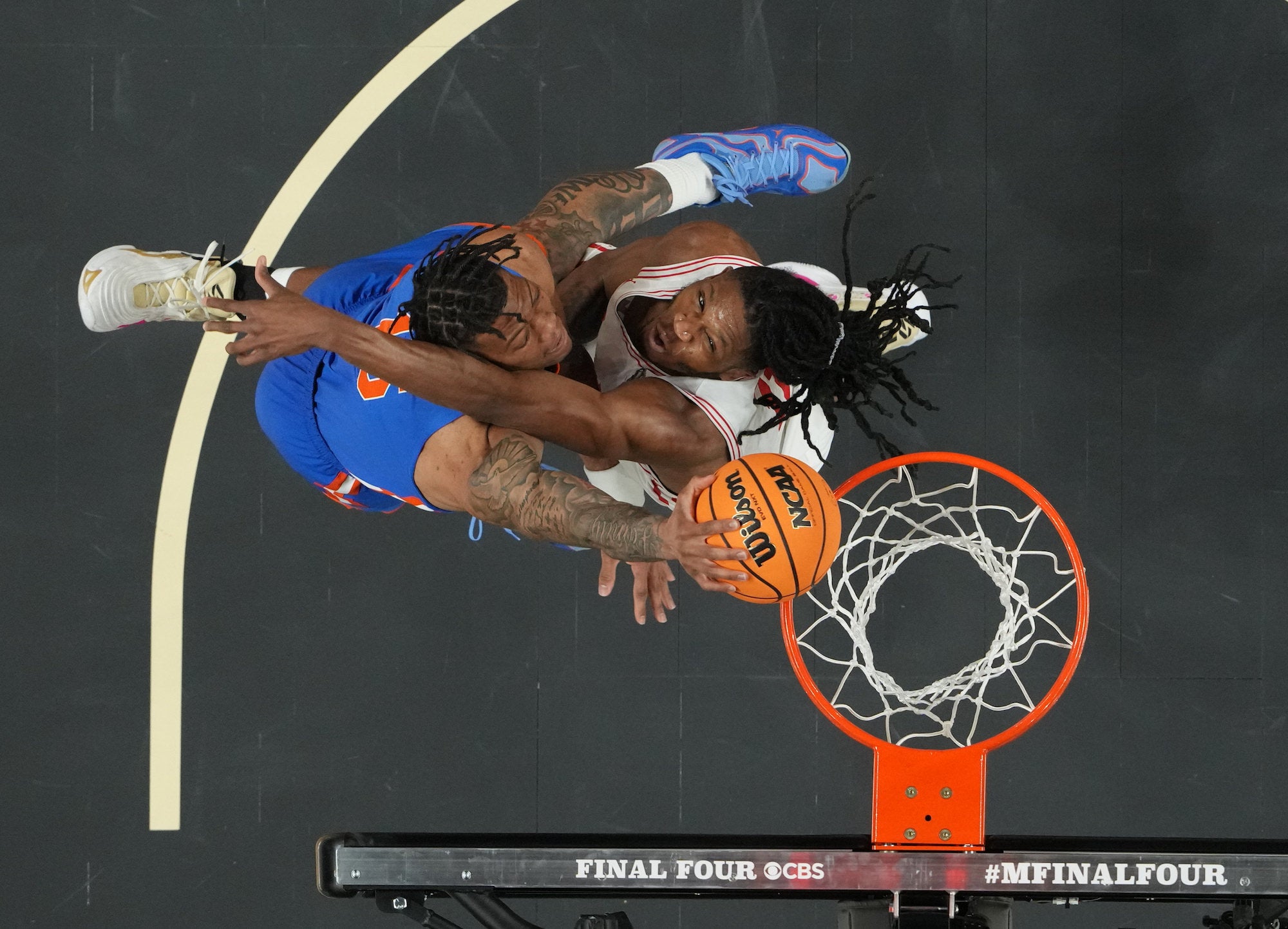 Overhead shot of a contested layup, two players colliding near the basket.